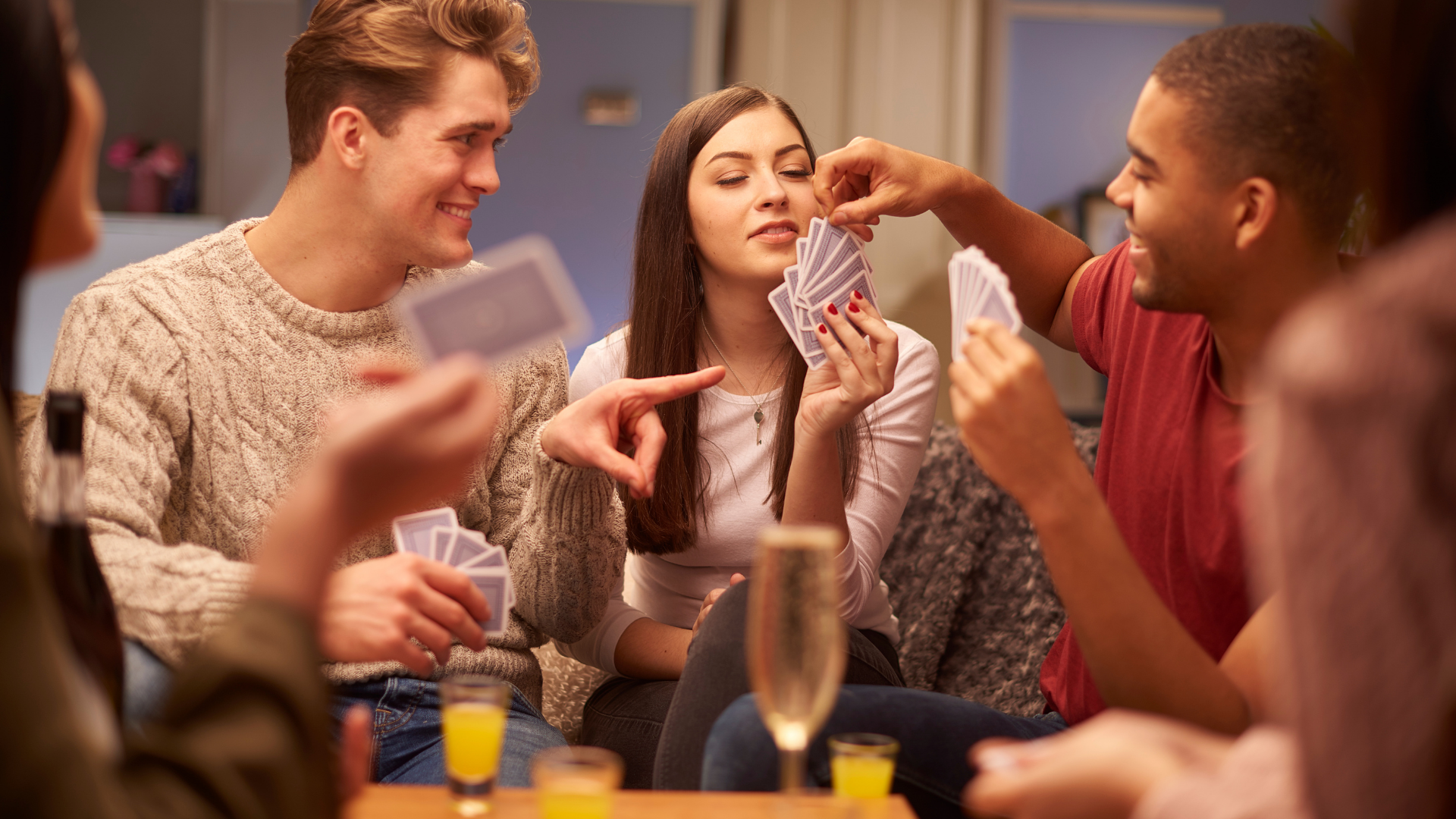 students laughing playing cards at table