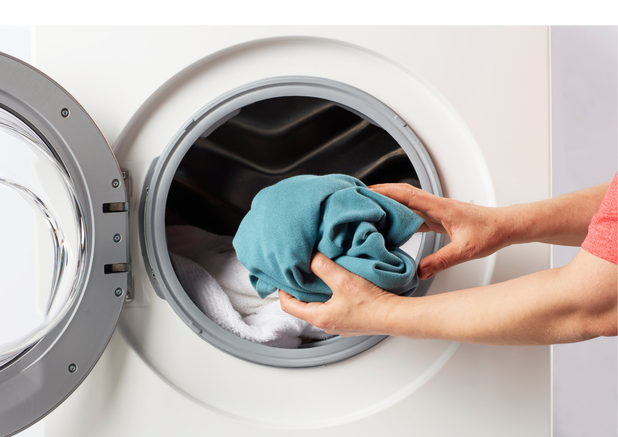 hands putting clothes in washing machine
