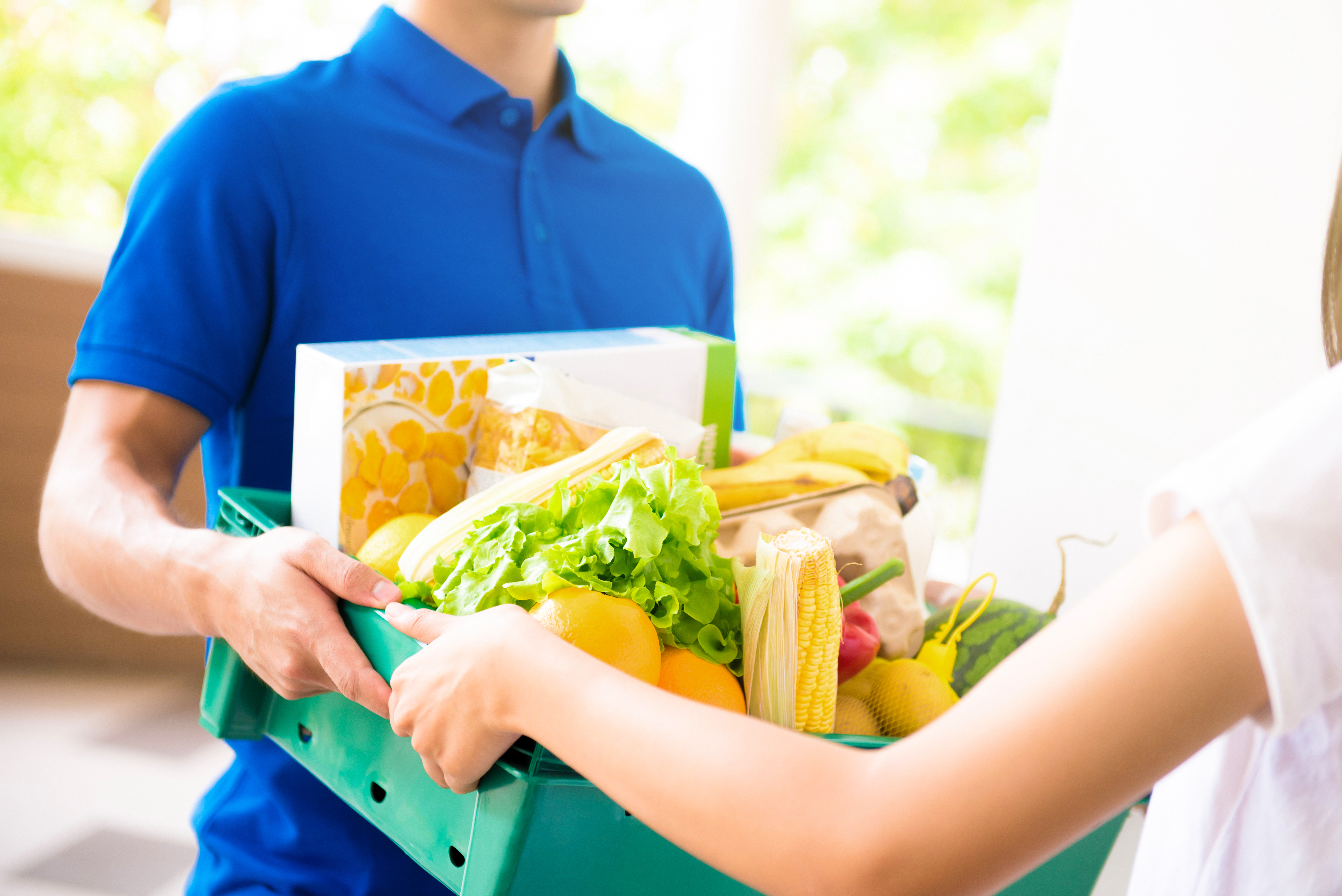 Delivery driver handing over box of groceries