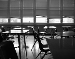 A black and white photograph of an empty classroom.