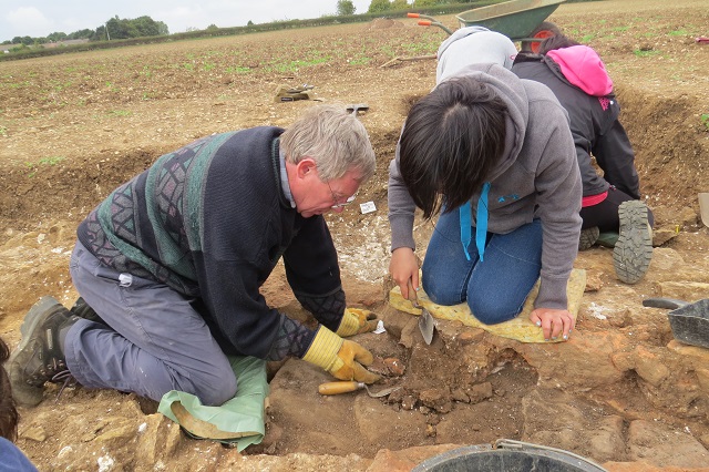 Alan and Valerie remove the baulk across Jonathan's corn-dryer following recording of the fills. Helpfully a Roman rim sherd was recovered which will help us date the use of the dryer.