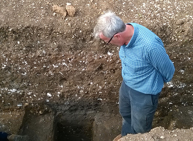 Graham contemplating how far off from reaching the bottom of feature 2020 we are, in our deepest excavated section.