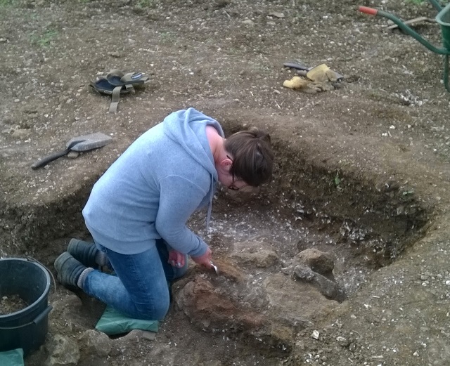 Toni carefully cleaning our newly discovered post pad within the Roman building, for a detailed photograph