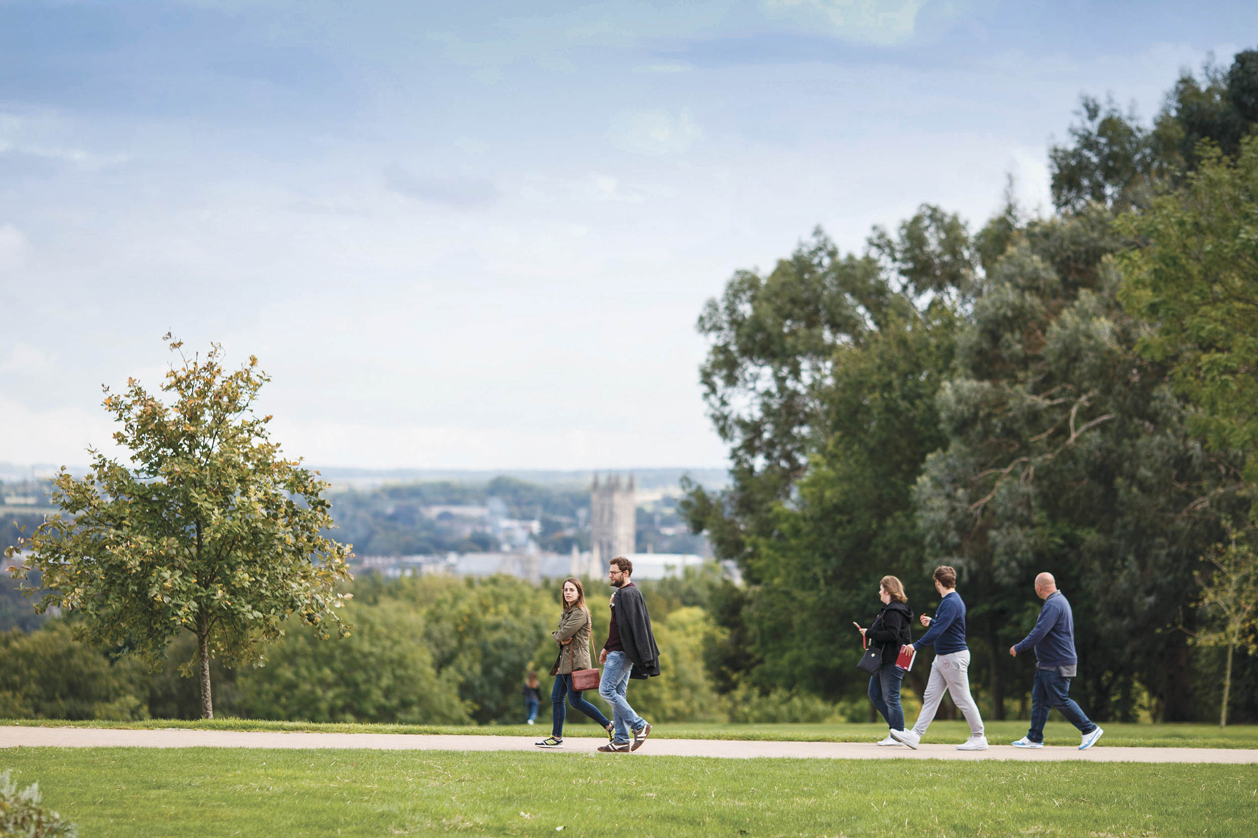 Students walking across campus with Canterbury cathedral in the background