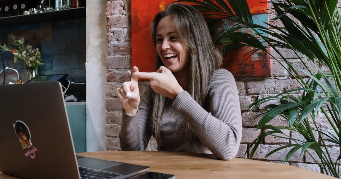 Woman with laptop using sign language on a video call