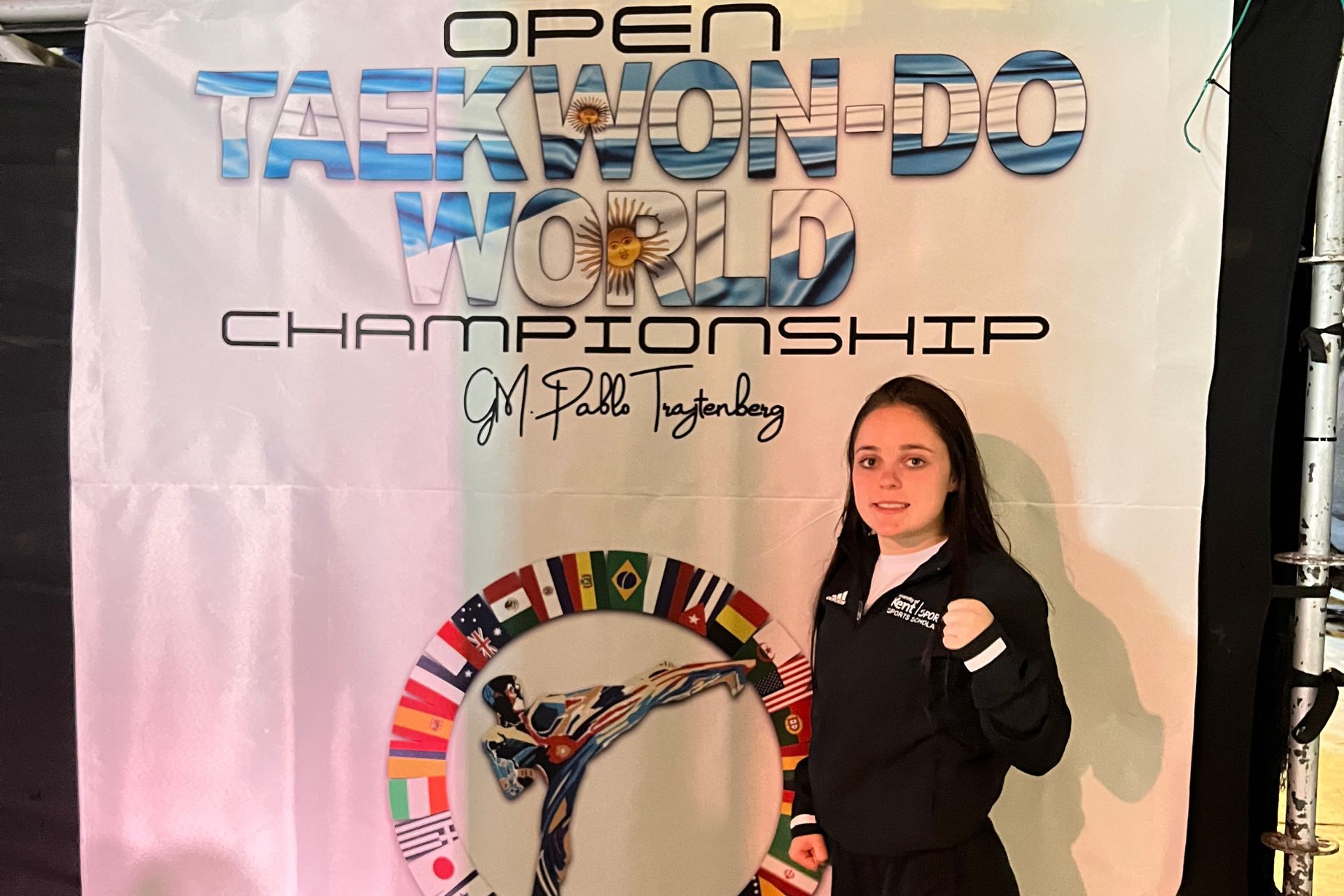 Emily standing in front of the Taekwondo World Championship's banner