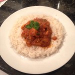 An image of chicken curry served with basmati rice