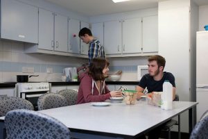 An image of students relaxing in a kitchen