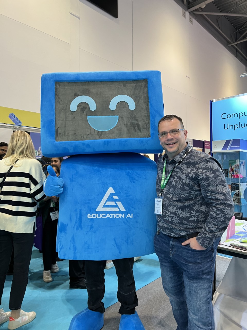 Steve Ganfield stood next to a blue robot company mascot