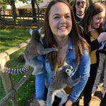 Felicia Dean surrounded by lemurs at a wildlife park