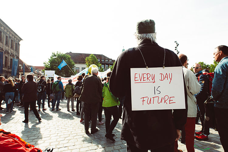 Climate change demonstrator with placard on his back emblazoned with 'Every Day is Future'