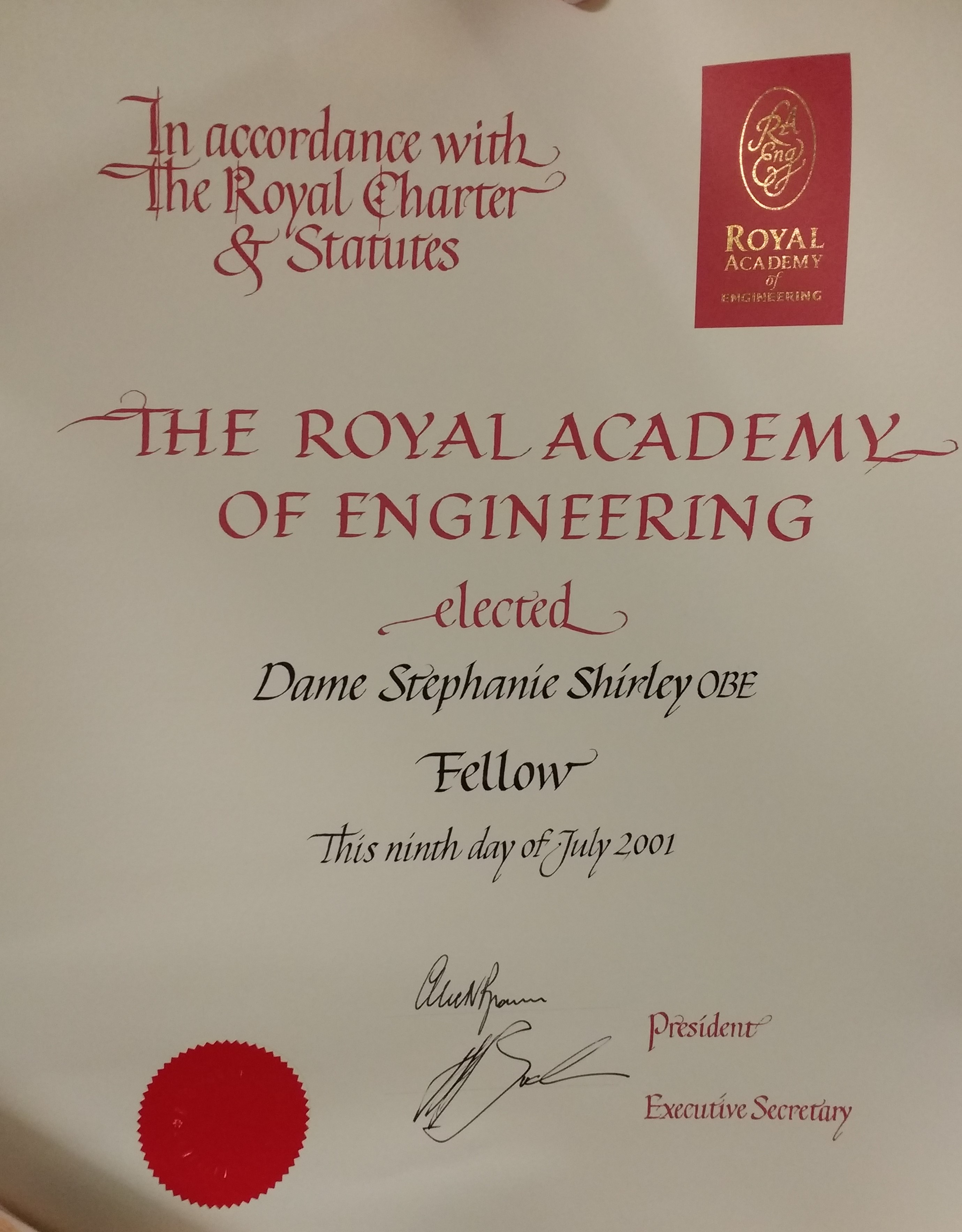 Certificate on cream paper with red and black lettering which reads "In accordance with the Royal Charter and Statutes The Royal Academy of Engineering elected Dame Stephanie Shirley OBE Fellow this ninth day of July 2001"