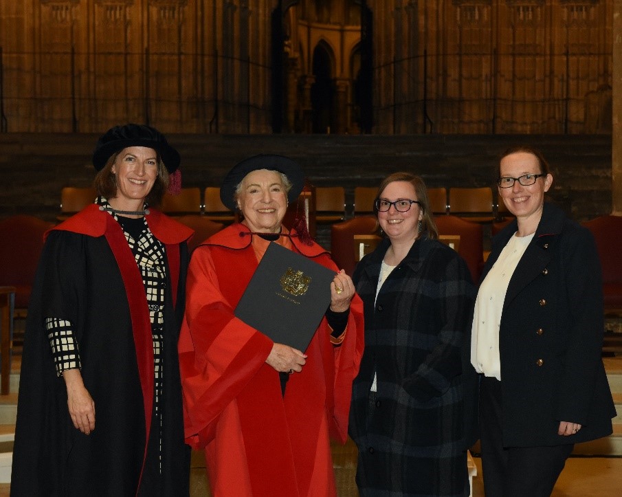 A photograph from the graduation ceremony. The image shows the following people standing together in a group (left to right): Dr Beth Breeze, Dame Stephanie Shirley, Rachel Dickinson, Beth Astridge.