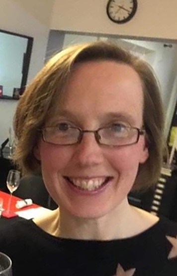 Head and shoulders image of Beth Astridge looking at the camera wearing glasses and a black top 
