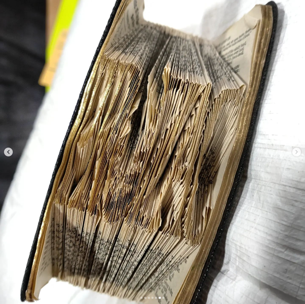Image of The book of common prayer, the text-block folded to reveal the word 'Prozac'.