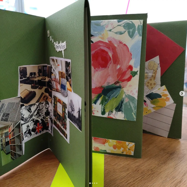 A hand-made T-cut book, with lots of different images pasted inside in scrapbook fashion.