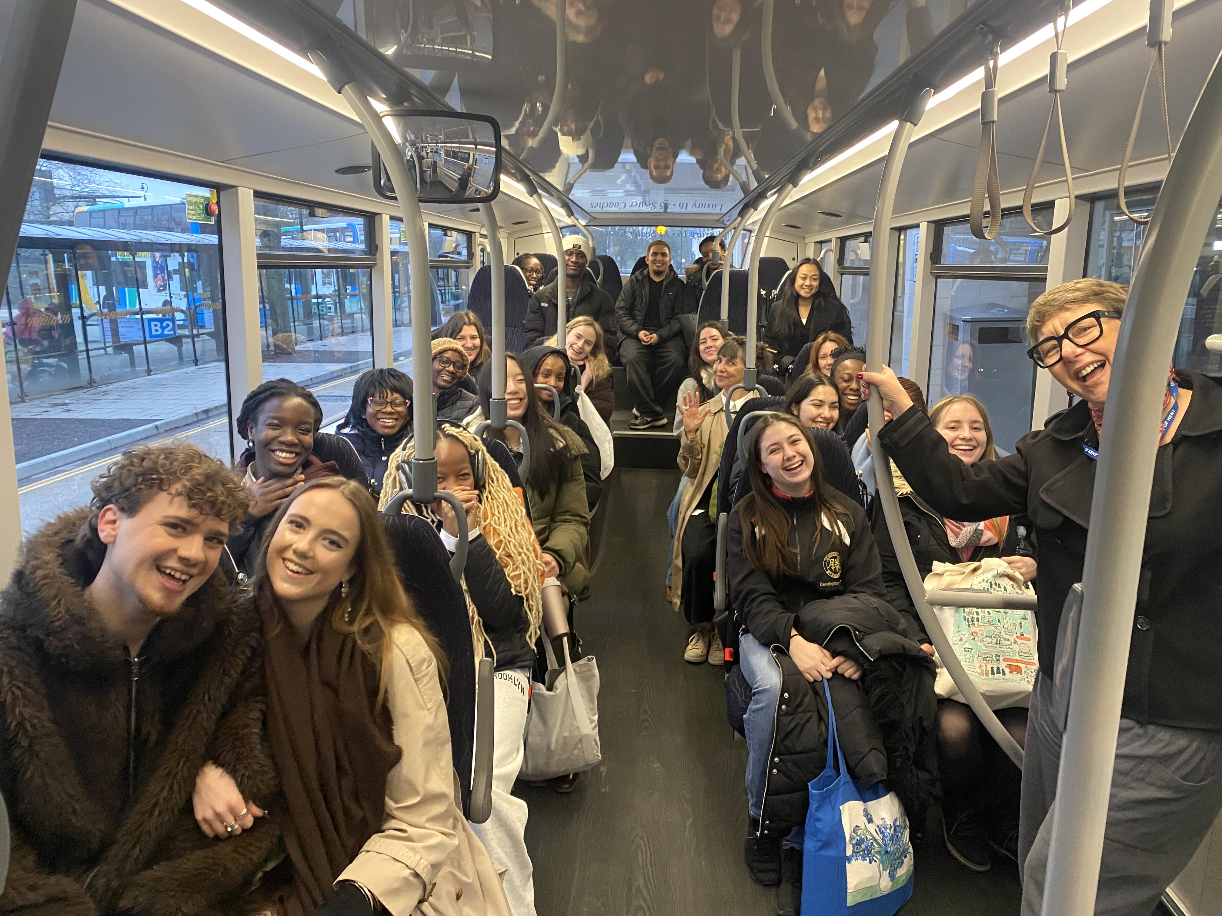 Students and staff smiling on the early bus to Fenwick fitting