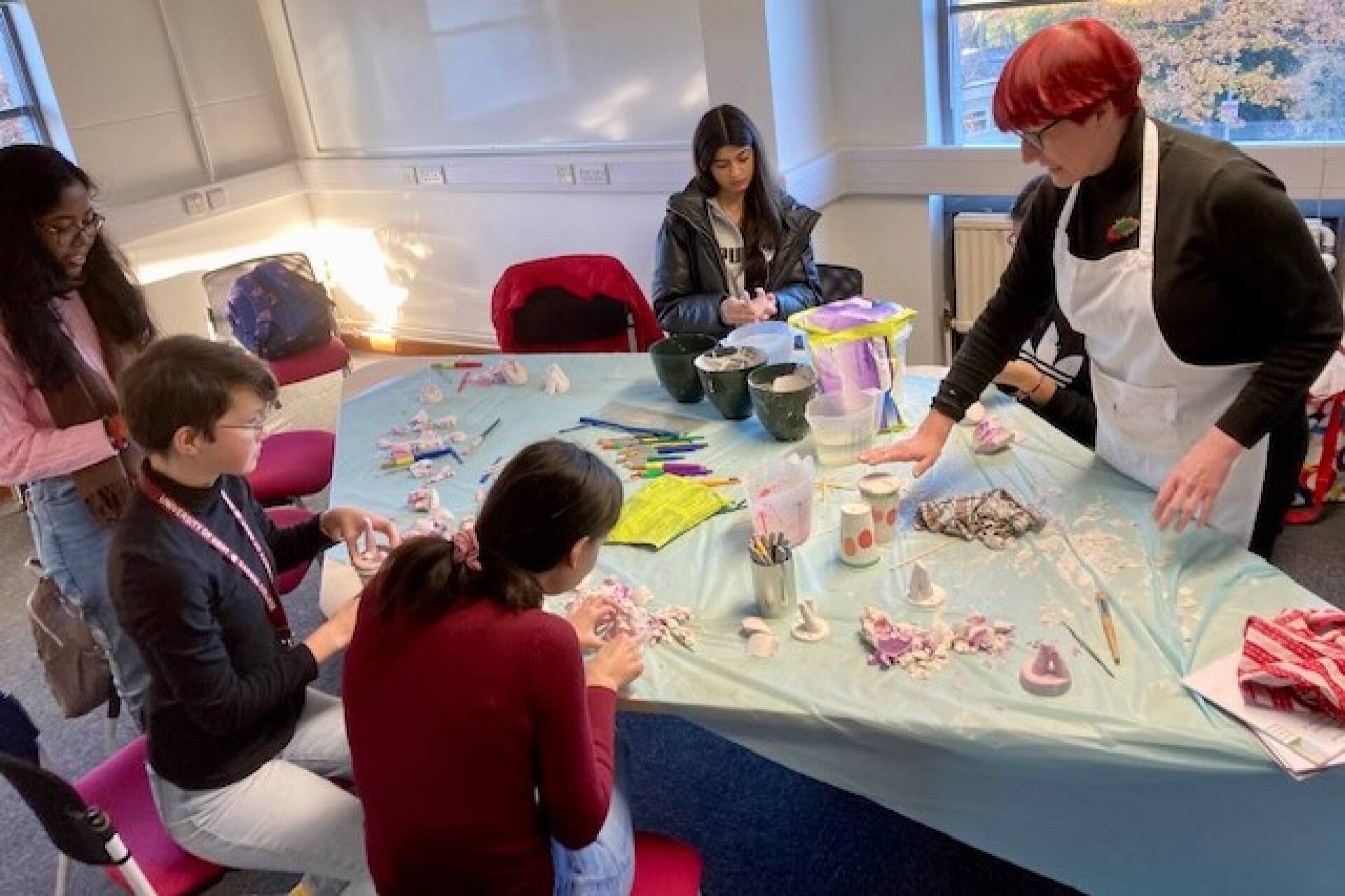 Group of students seated at a table with craft activities.
