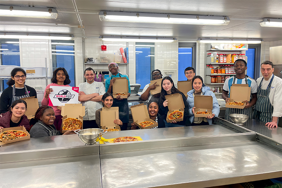 Students show off their pizzas after a successful cookery workshop
