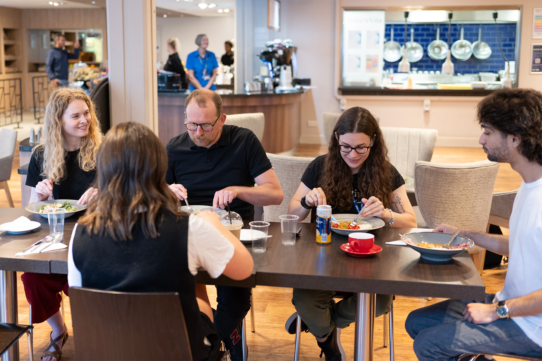 A group of staff and students sit together at Dolche Vita to enjoy lunch