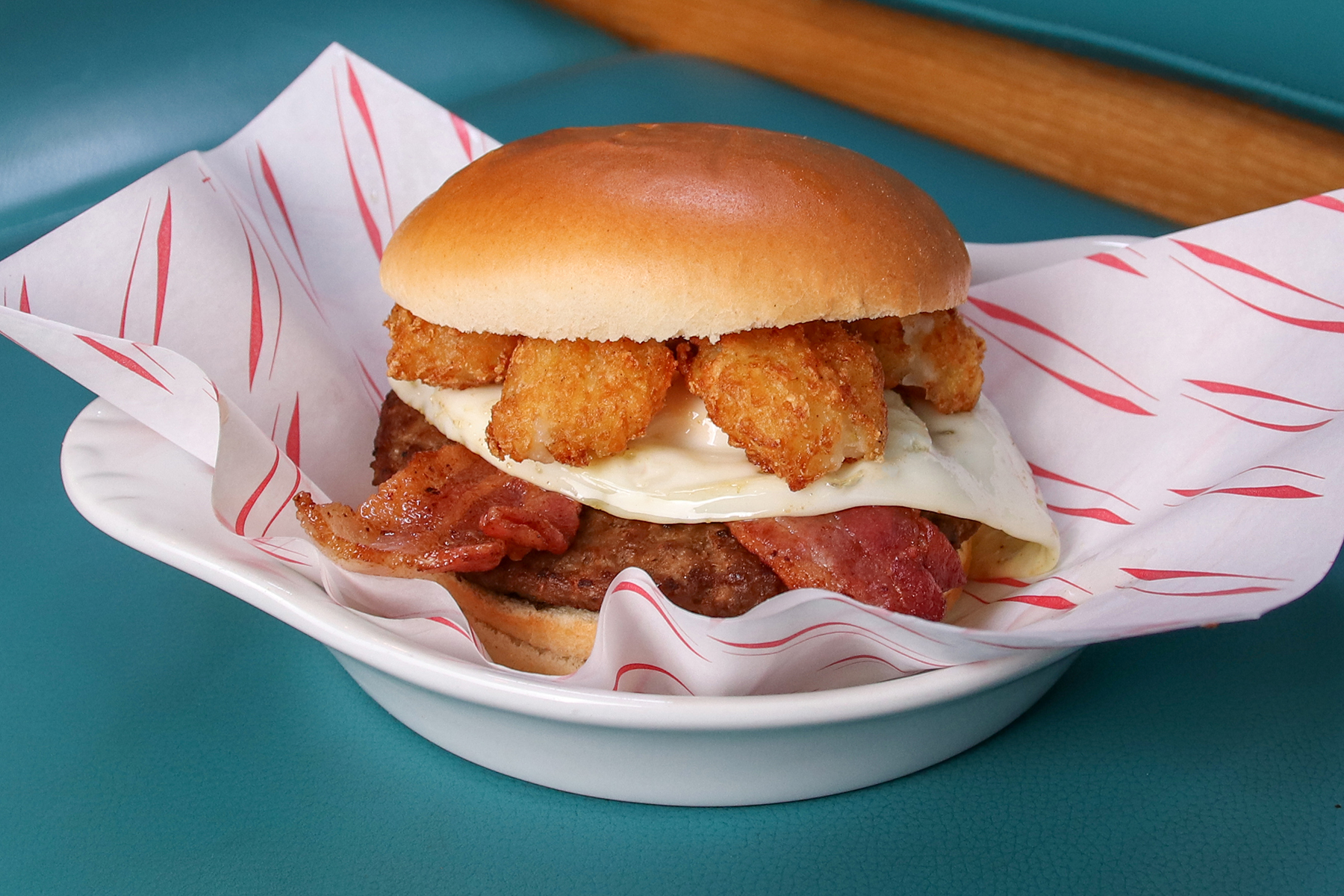 Breakfast Burger: a juicy beef patty topped with crispy bacon, a fried egg, and mini hash browns, all packed into a soft glazed bun