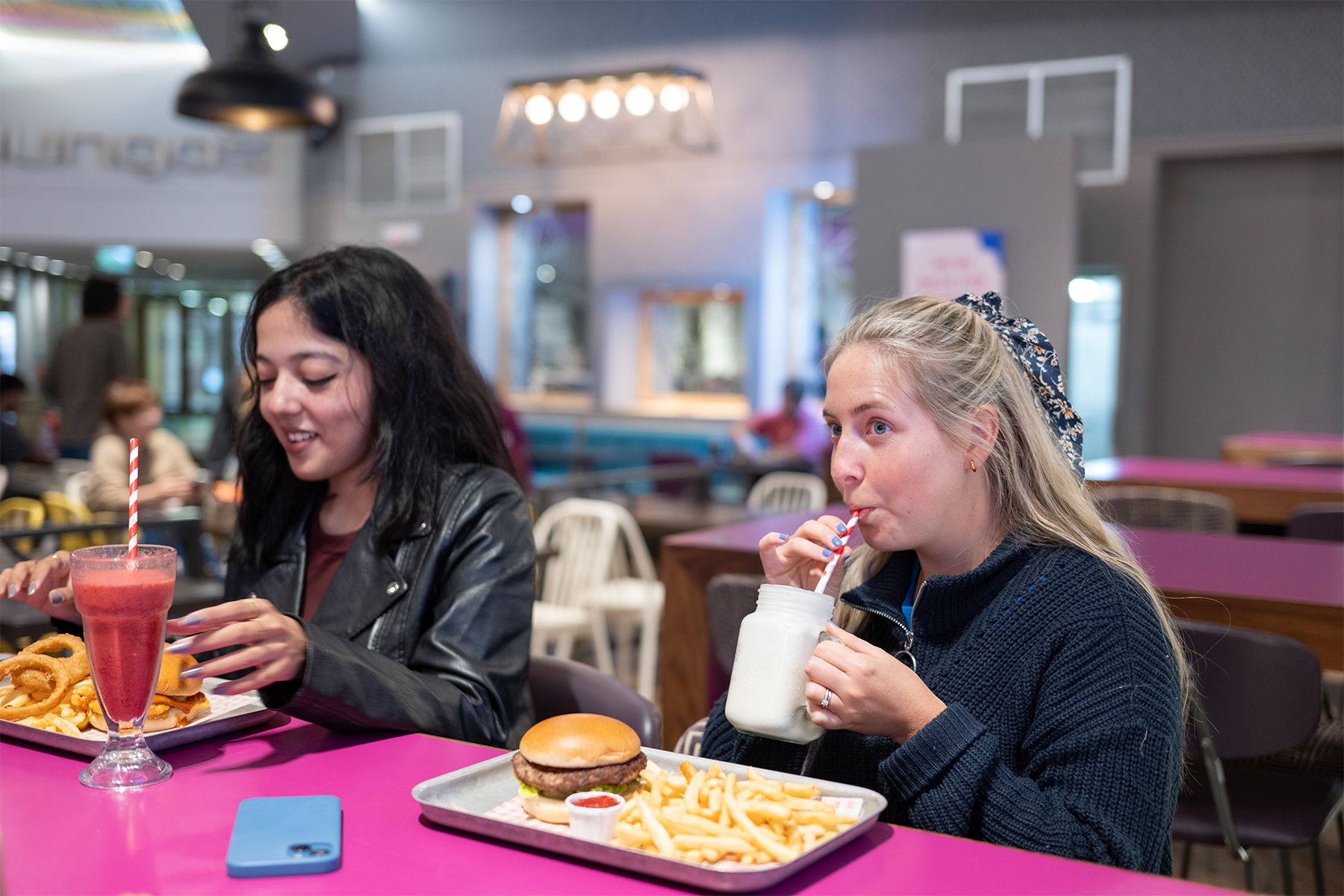 Two young customers enjoy burgers and milkshakes at Mungo's