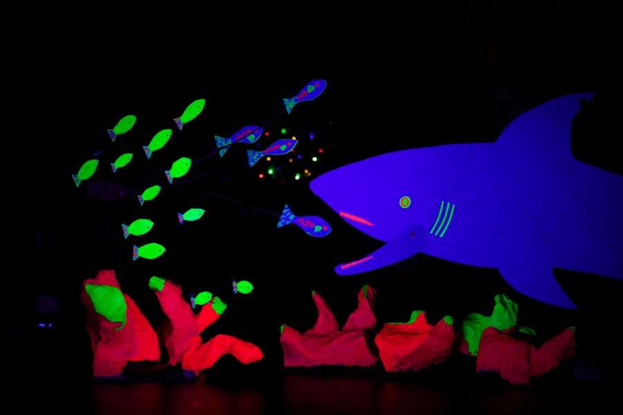 An installation of artwork under UV light, showing a scene underwater; one of the installations prepared by the Imagining Autism project.