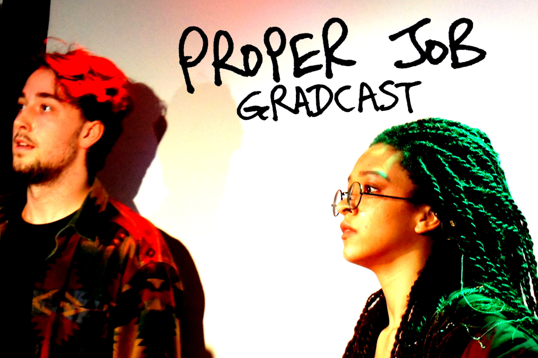 Proper job gradcast image featuring two performers illuminated by coloured stage lighting.