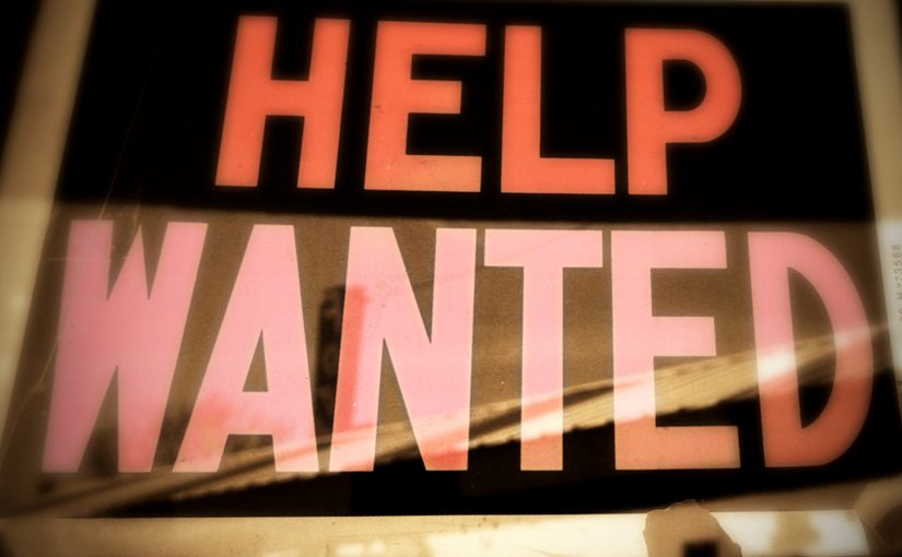 Neon sign that reads "HELP WANTED"