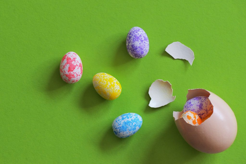 pastel coloured eggs on green background