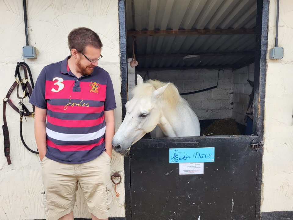A man stands next to a horse