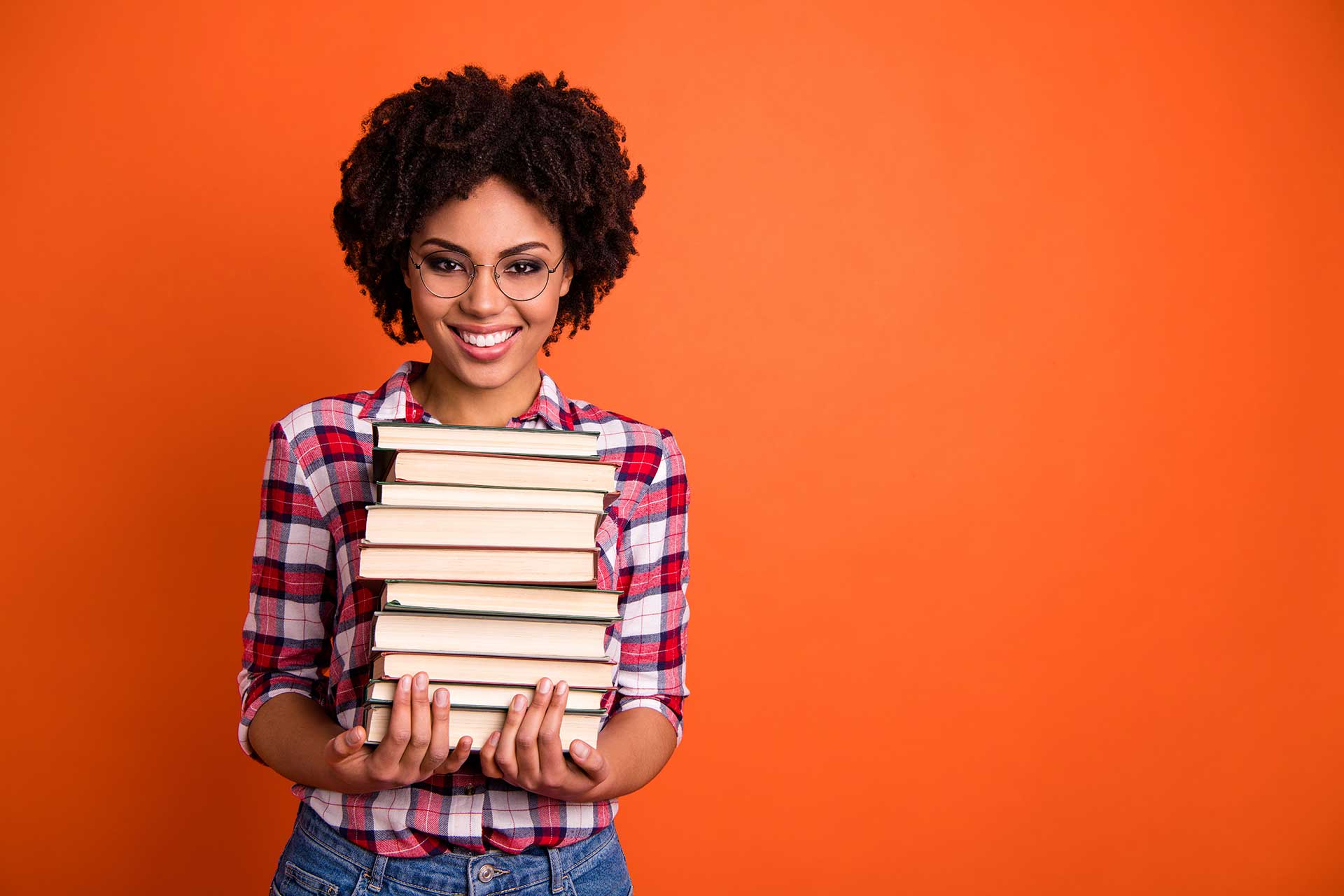 Student holding pile of books