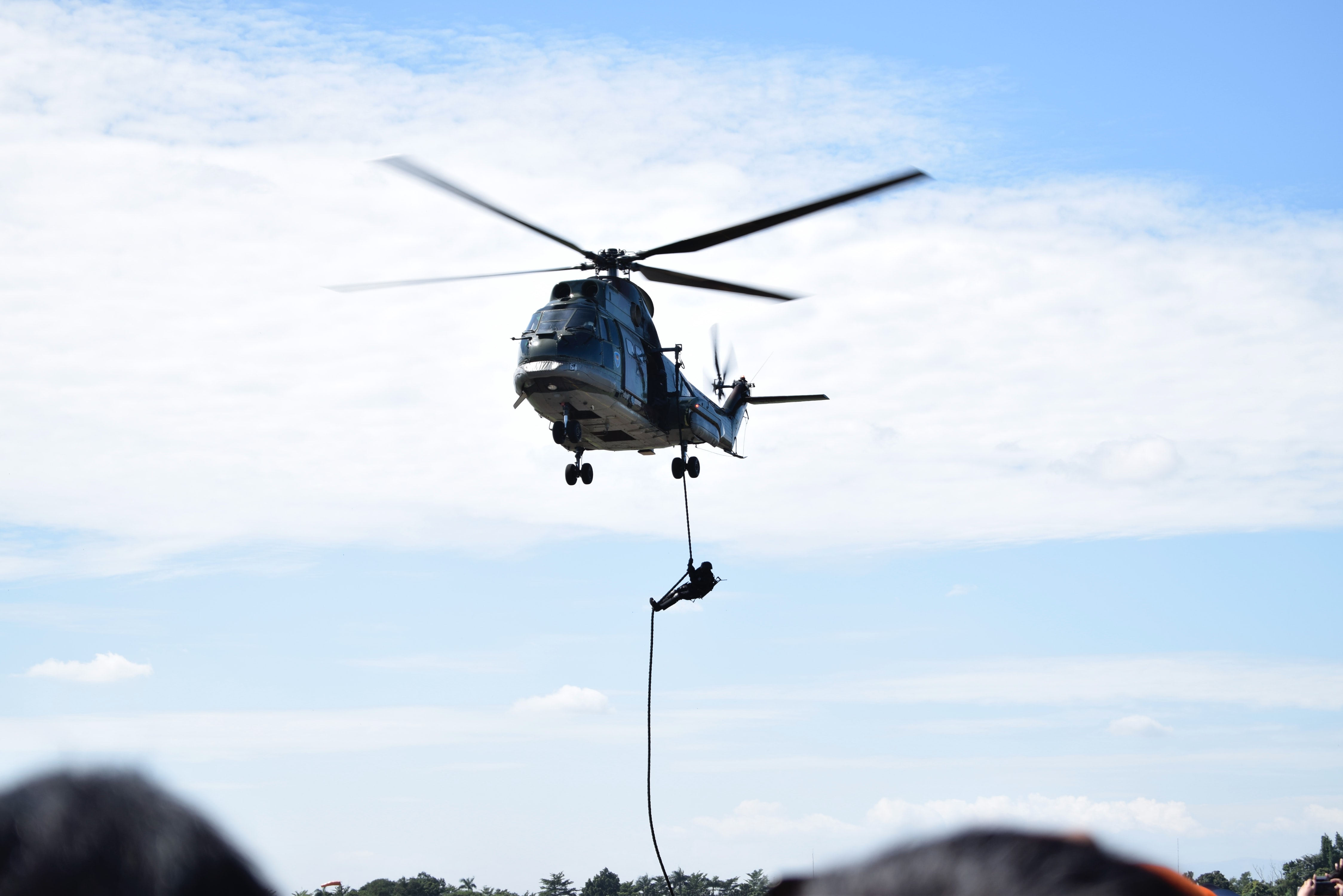 an army recruit abseiling from a helicopter
