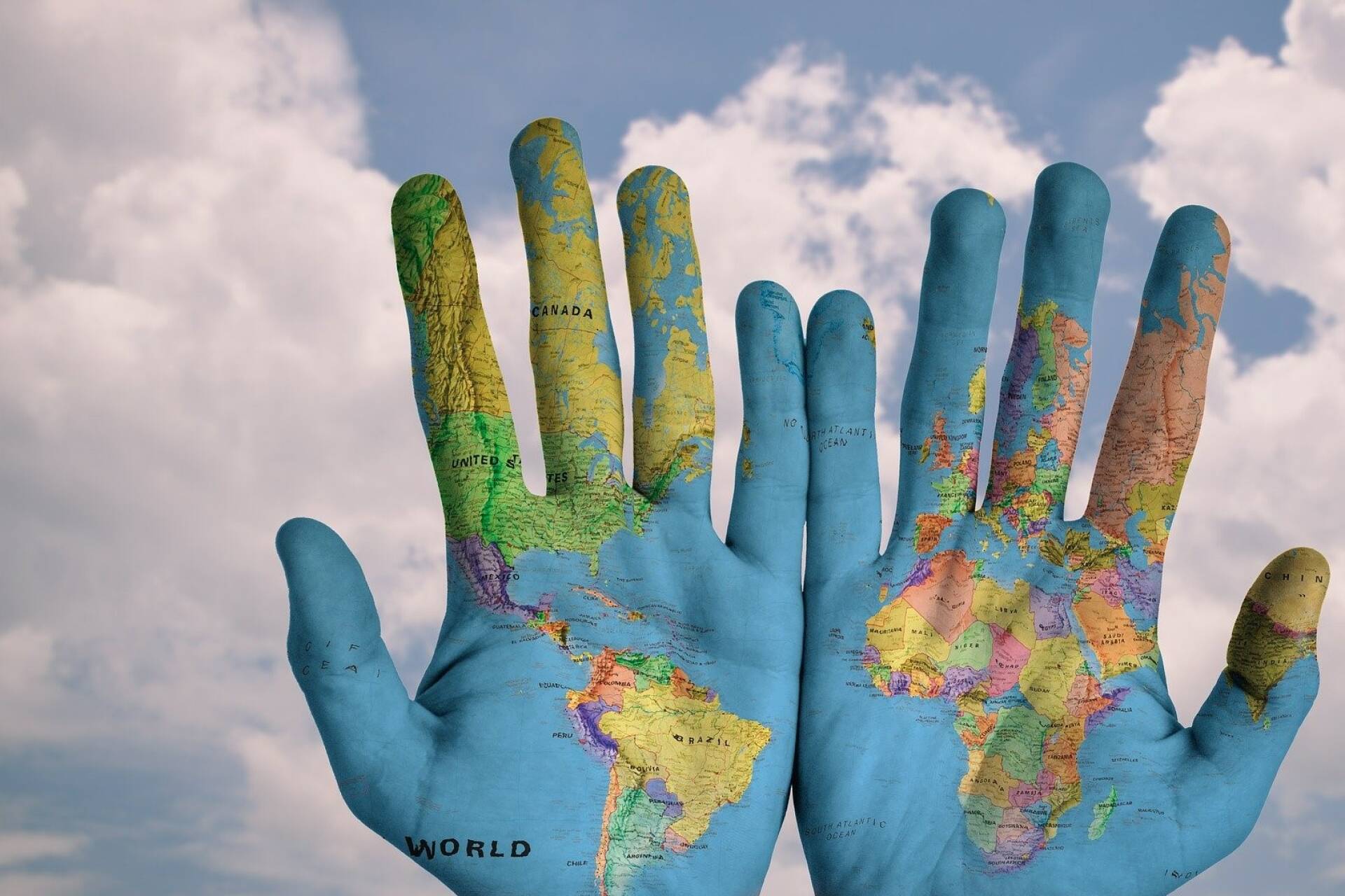 two hands overlaid with a world map