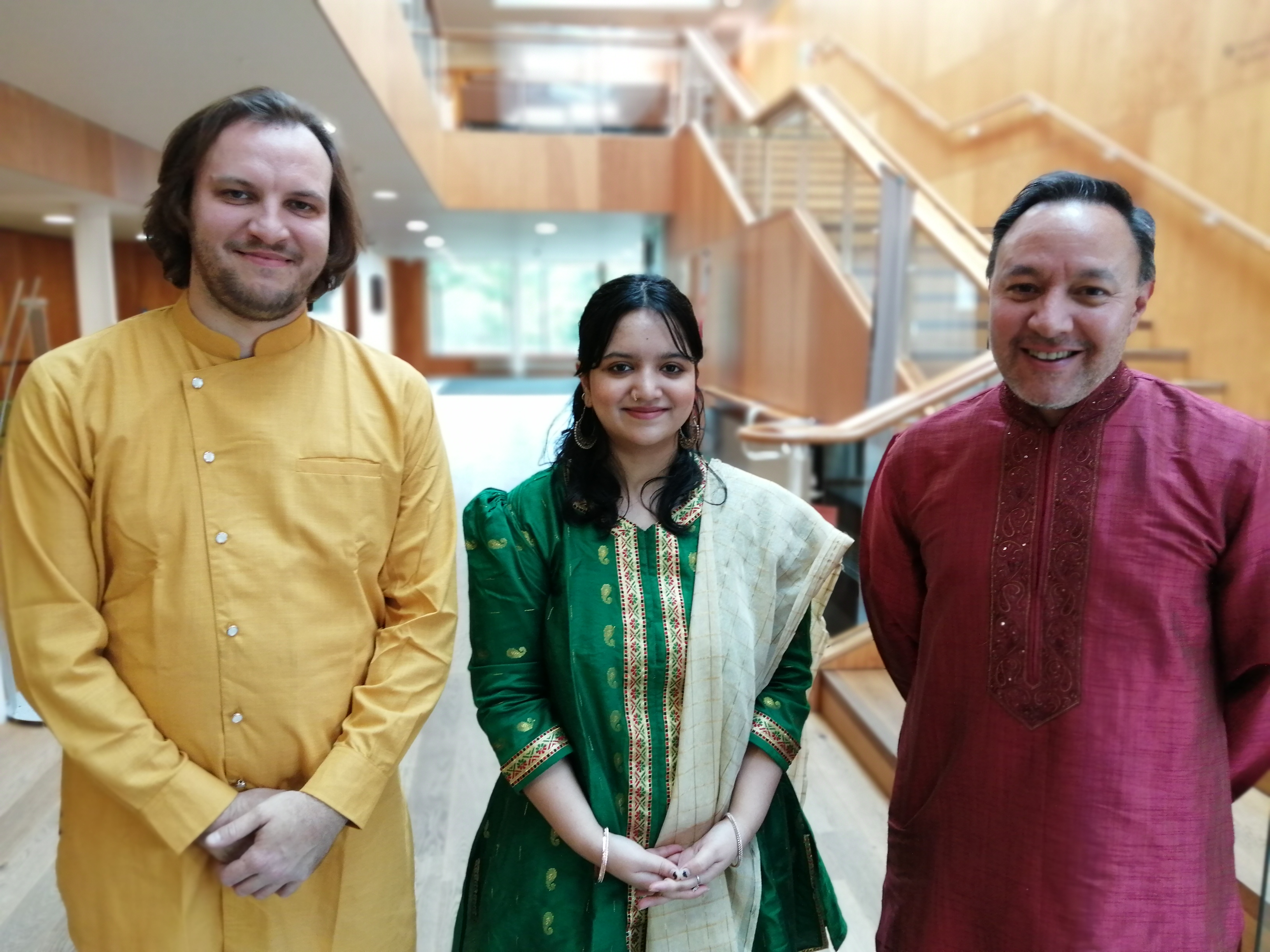 Three musicians in Indian dress standing in the foyer of Colyer-Fergusson Hall, including third-year student Ridima
