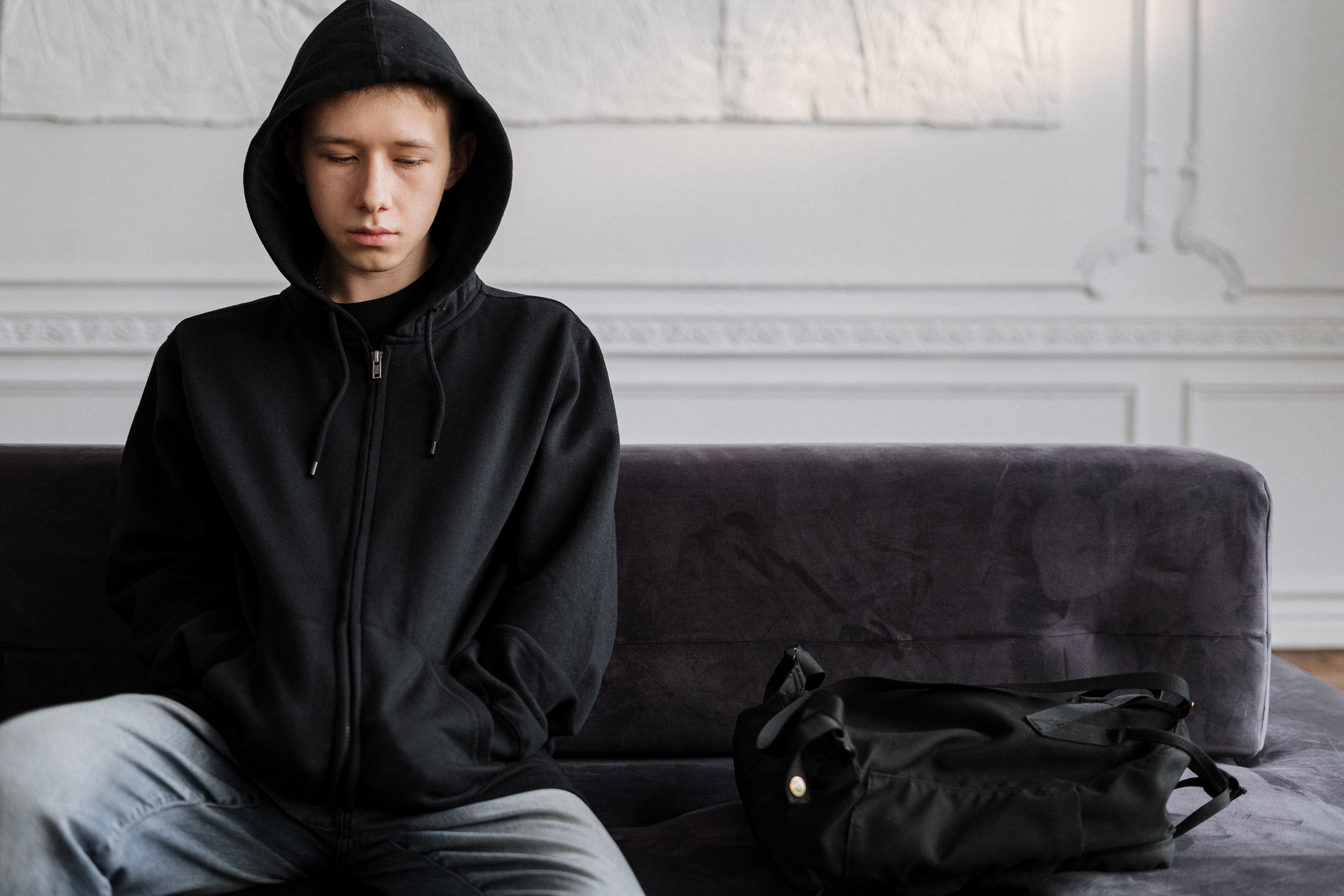 Young person looking down wearing hooded jumper