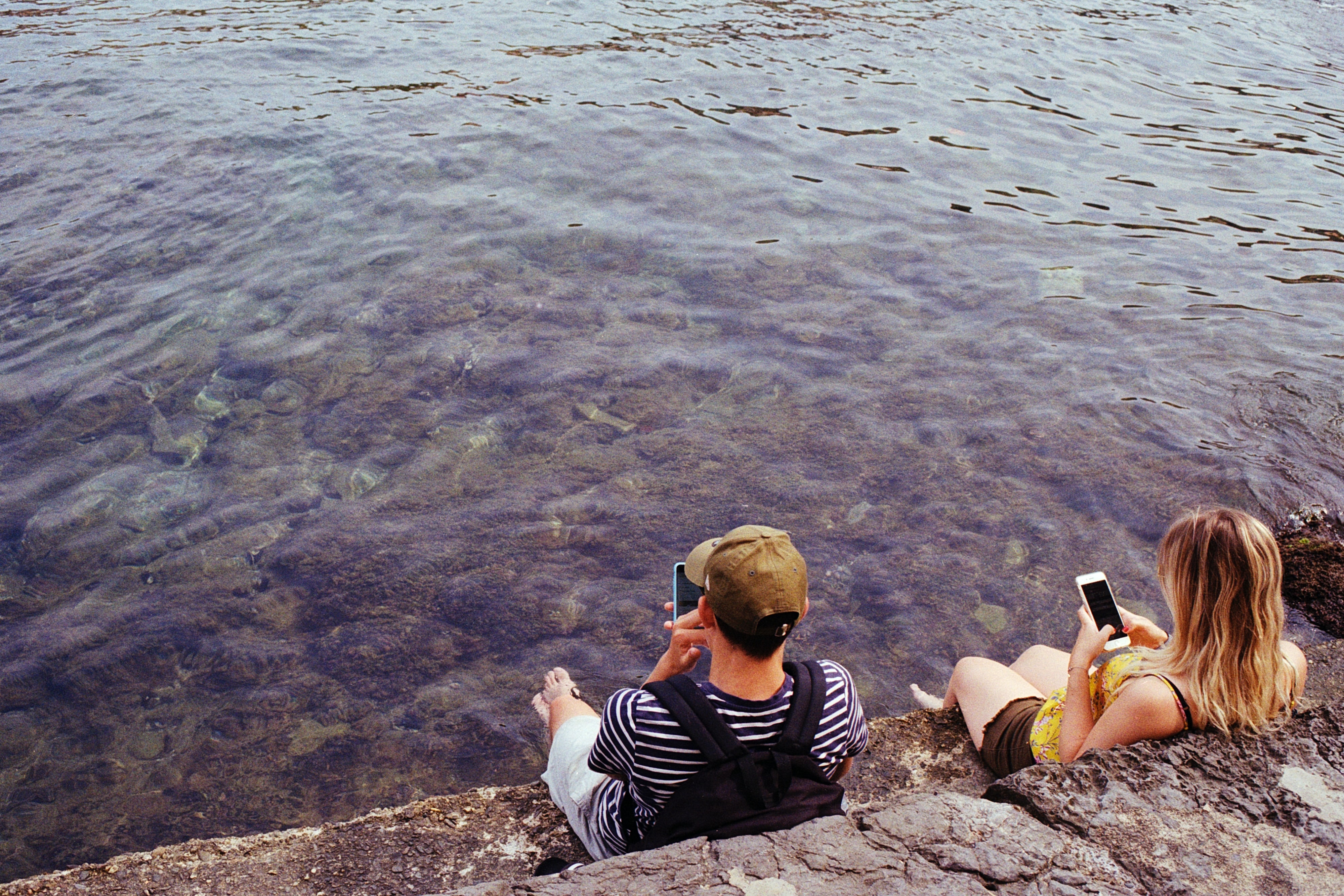 teenagers on their phones by the sea