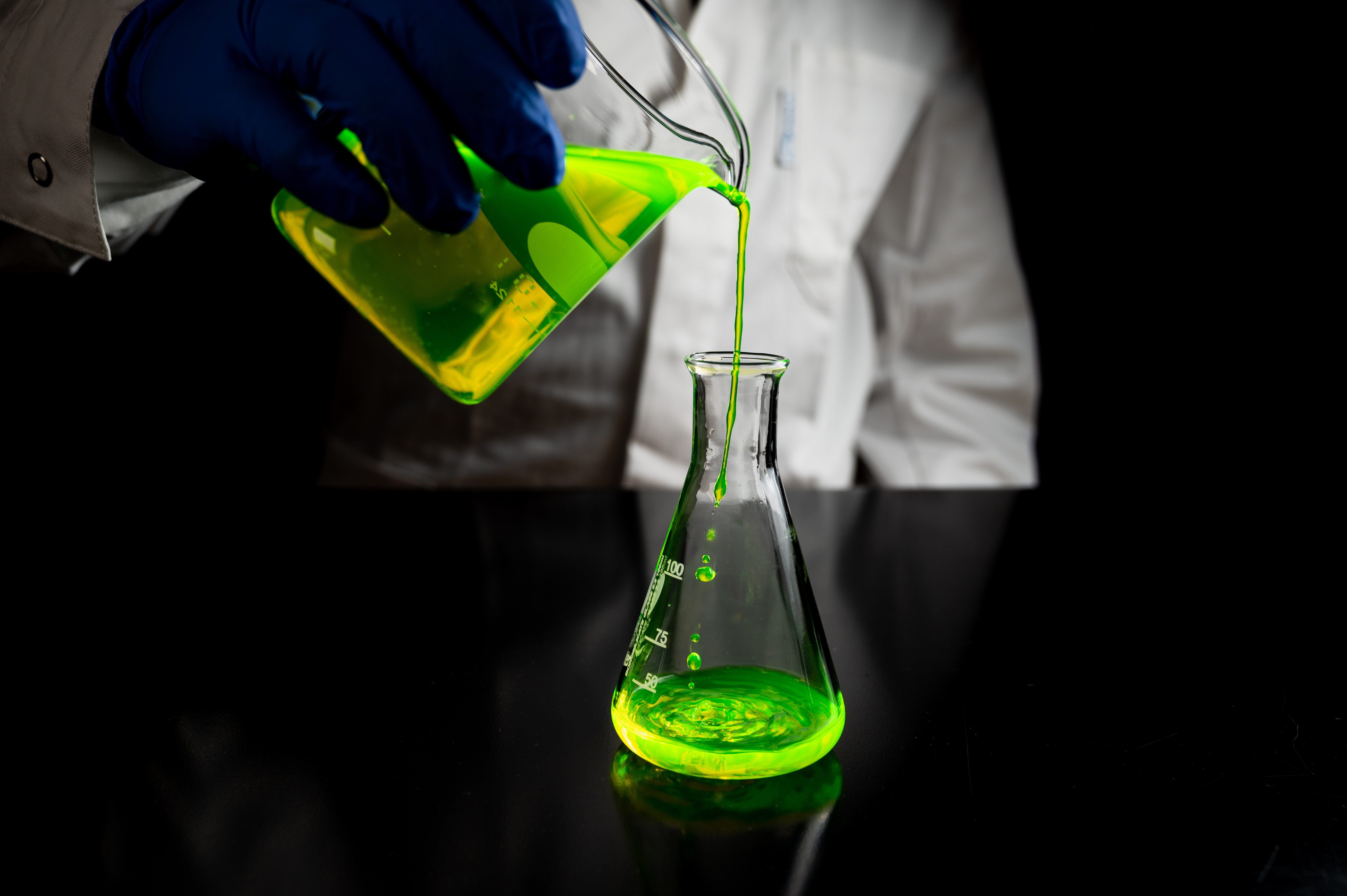 A research scientist experimenting with a green fluorescent drop