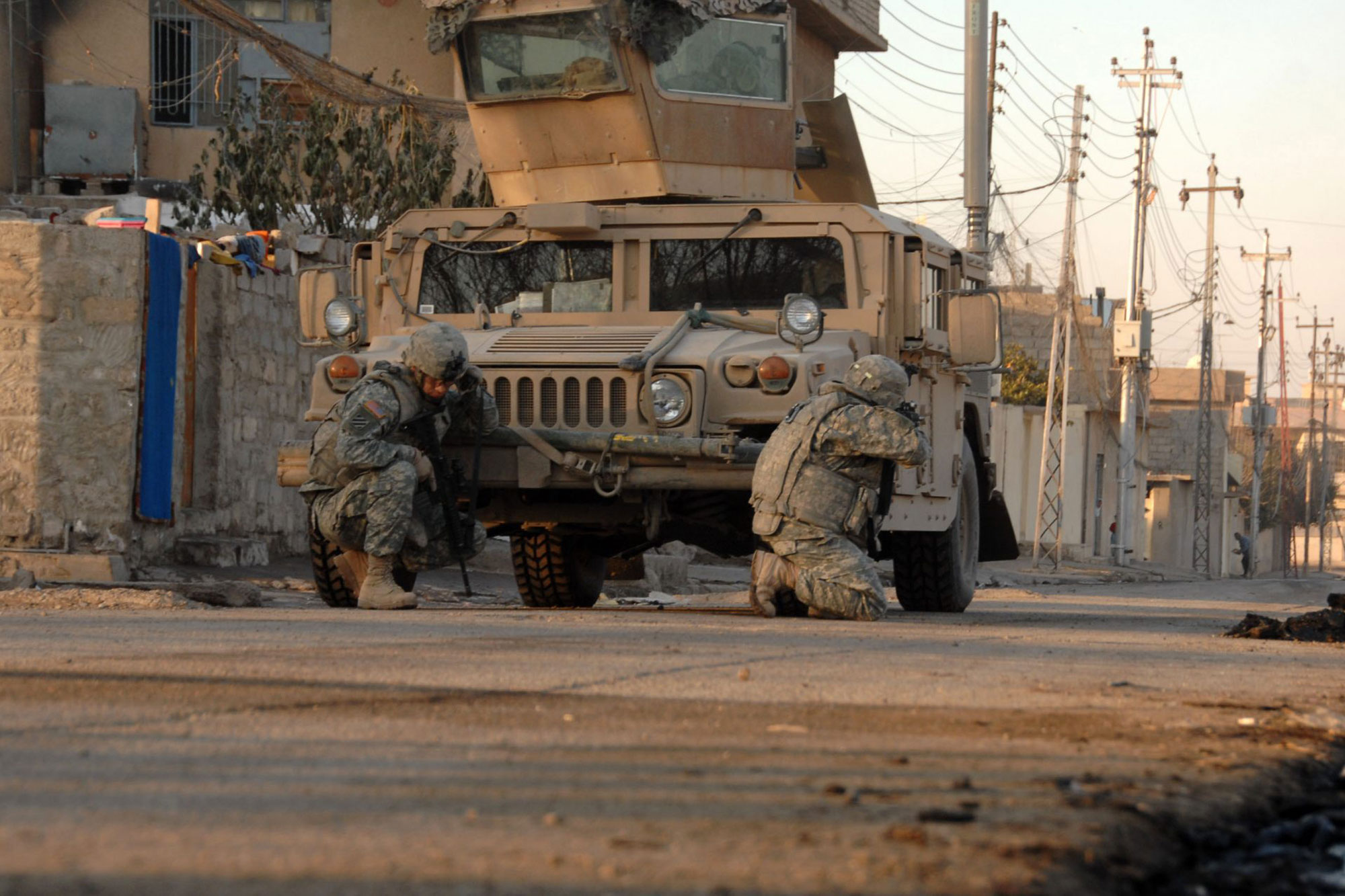 U.S. Army Soldiers, Heavy Company, 3rd Squadron, 3rd Armored Cavalry Regiment, take cover as they hear small arms fire open up in the distance in Mosul, Iraq, on Jan. 17, 2008.