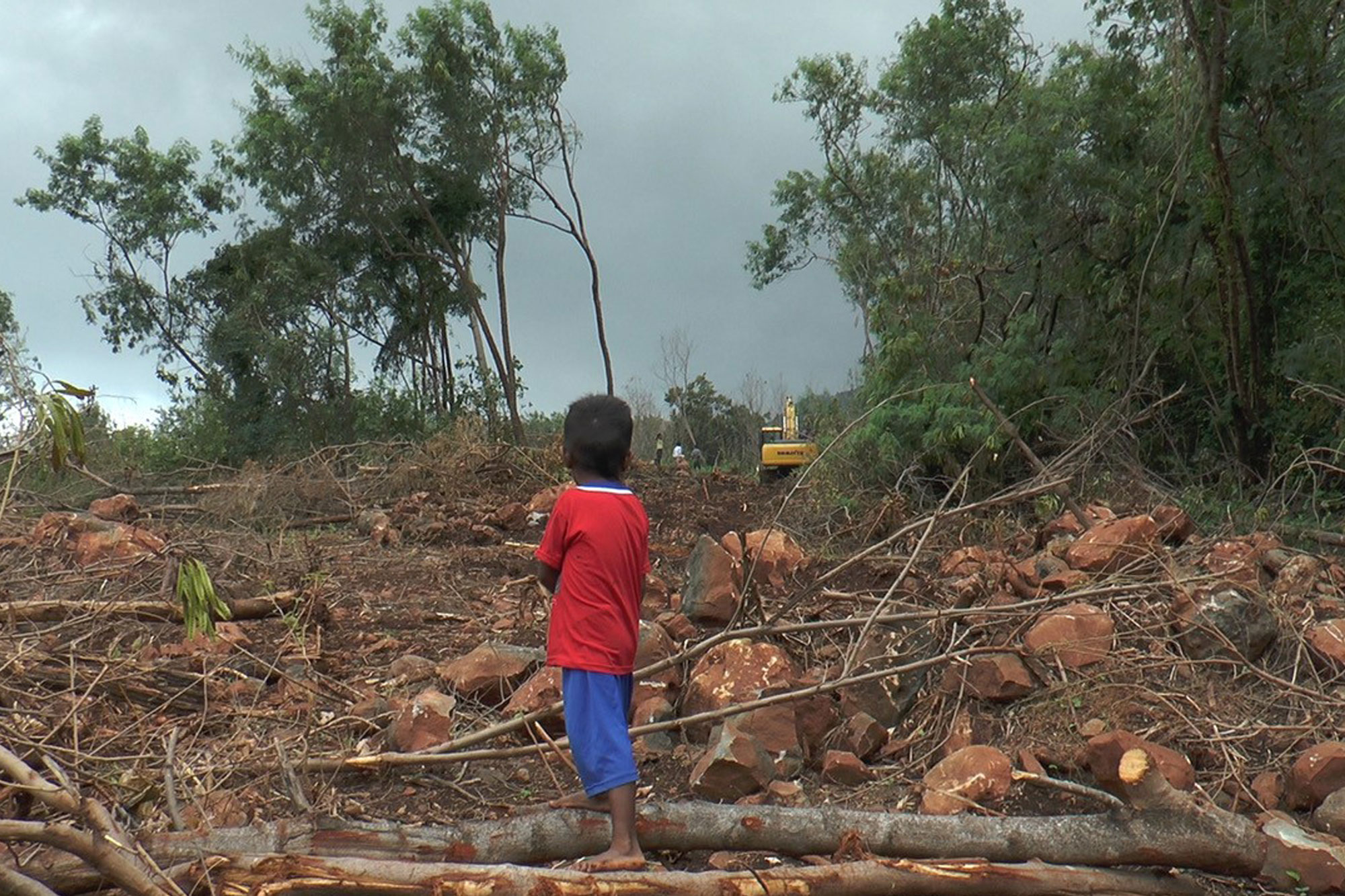 Still from film - boy standing in devastated landscape