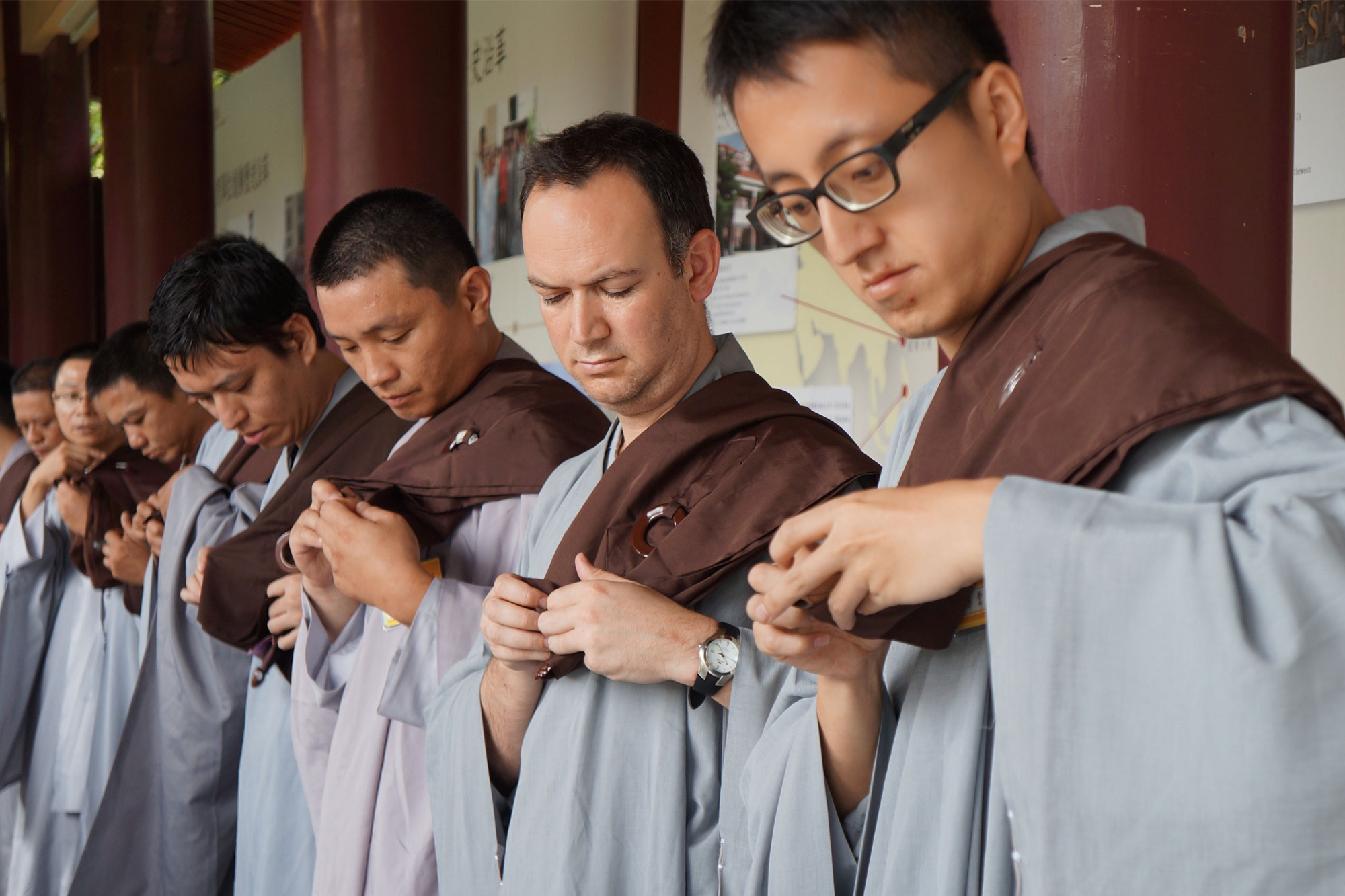 Dr Jonathan Mair with Fo Guang Shan monks fastening their robes