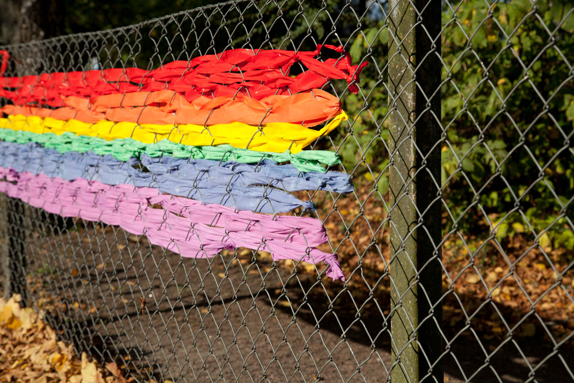 Pride flag woven into chainlink fence