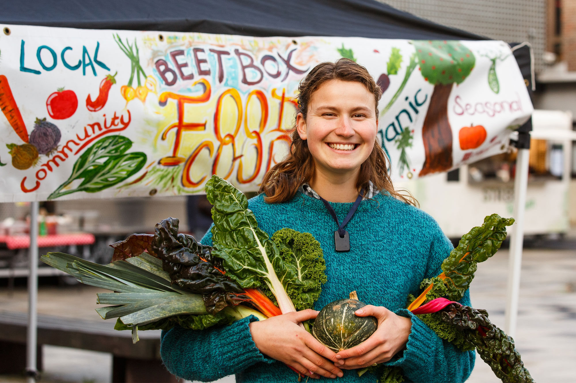 Olivia Haywood-Smith holding fresh vegetables outside her Beetbox stall