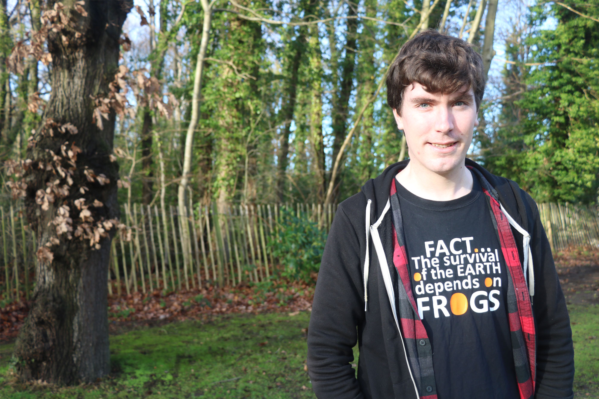 Steven Allain outside with T-shirt emblazoned with 'FACT...The survival of the earth depends on frogs'.