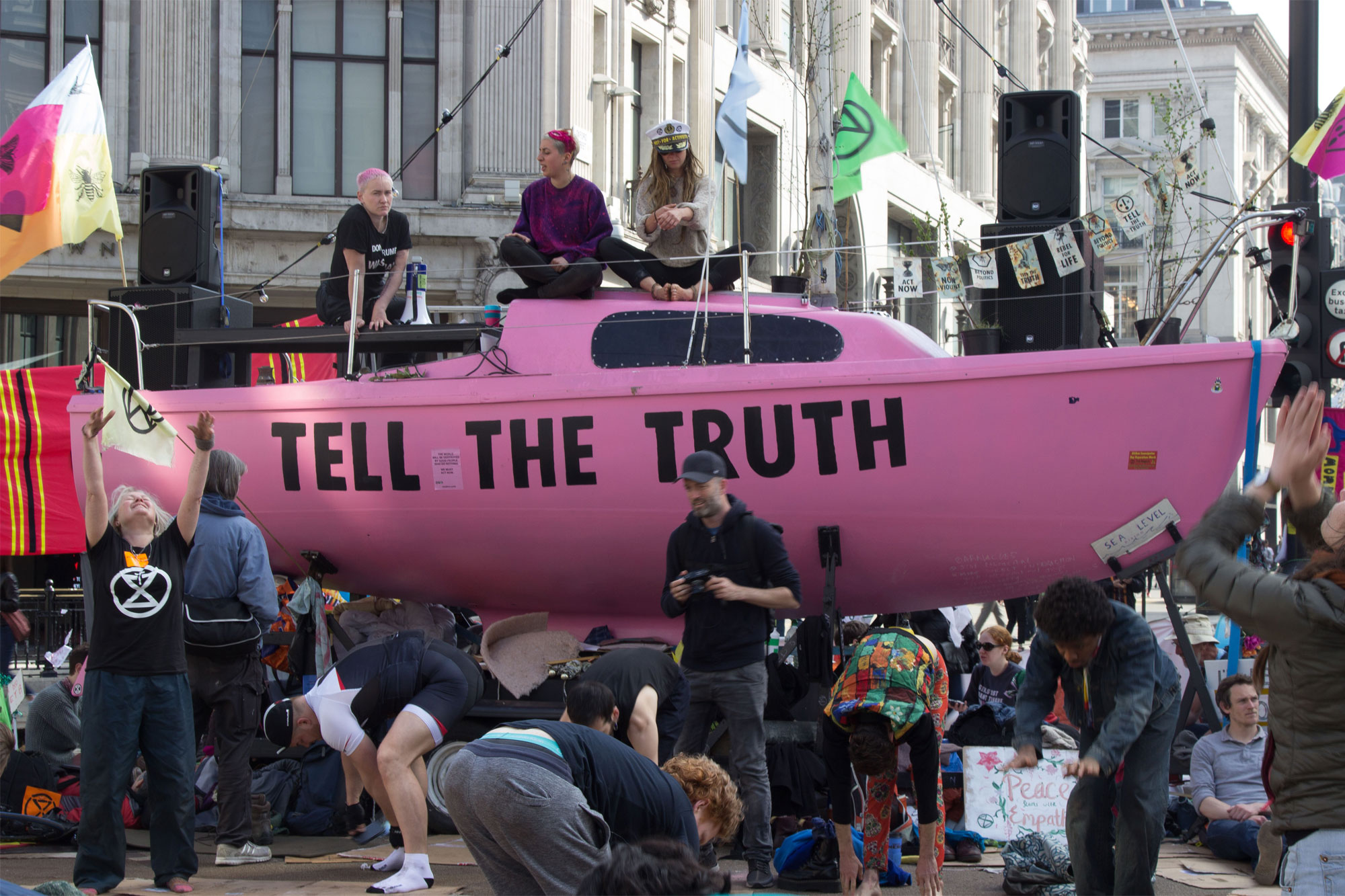Extinction Rebellion protesters gathered around a pink boat emblazoned with the slogan 'Tell the truth'