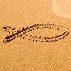 A fish drawn in the sand, representing Christianity. Courtesy of iStockphotos.