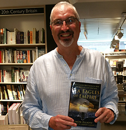 PhD student Simon Elliot holds a copy of his book 'Sea Eagles of the Empire'