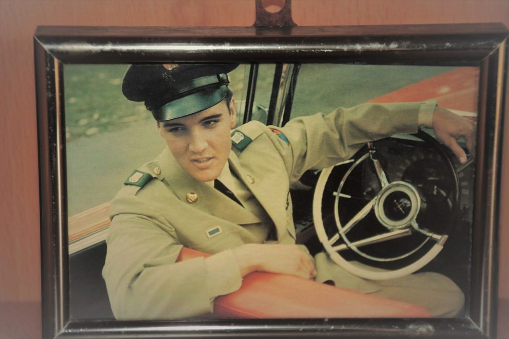 Elvis Presley with military uniform sitting in a car