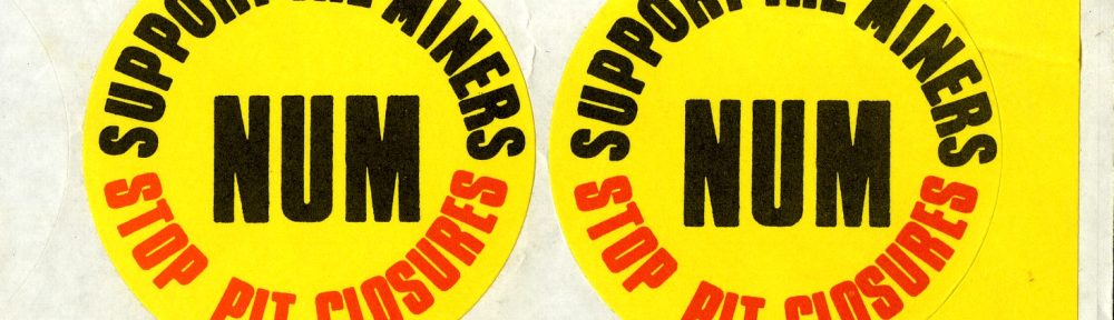 Two round yellow stickers with black and red text reading "Support the Miners NUM Stop Pit Closures"