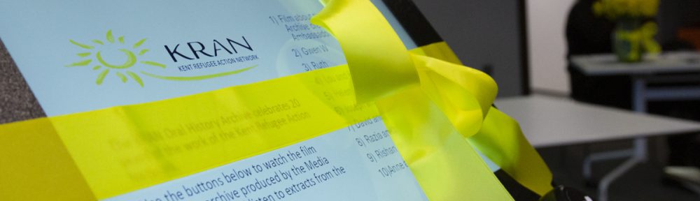 Screen displaying information about the KRAN Oral History Archive tied in a yellow ribbon